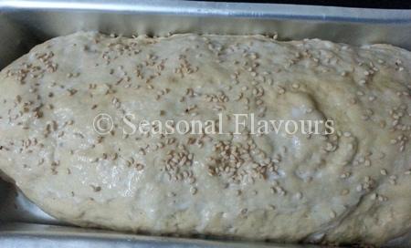 Brush bread dough with milk and sesame seeds