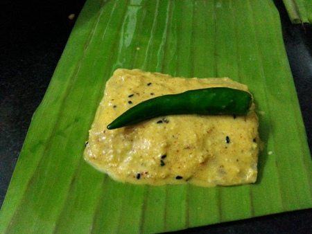 Place marinated bhetki fish fillets on banana leaves