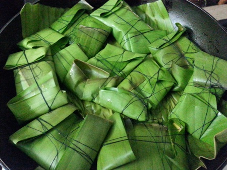 Place banana leaf wrapped fish parcels in a frying pan