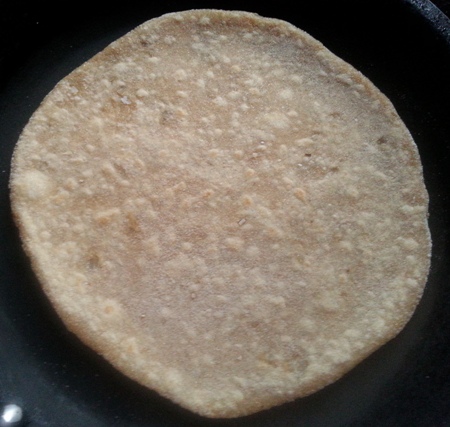 Cook paratha with coconut filling on griddle