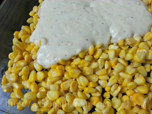 Drizzle white sauce on corn kernels