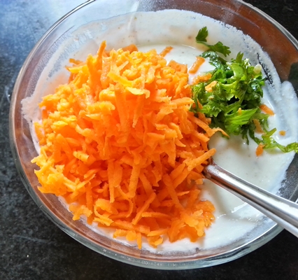 Mix in carrots, coriander and chilli with curd for raita recipe with carrot
