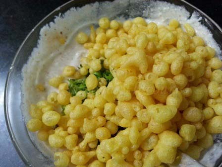 Add fried gram flour balls to spiced dahi