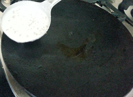 Pouring batter onto the tava