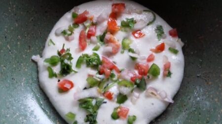 Sprinkle topping on Uthappam