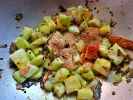 Add spices to the ridge gourd curry