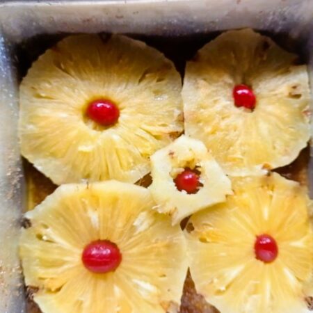 Place pineapple rings in the base of the pan