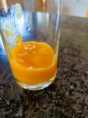 Spoon Mango compote into glasses