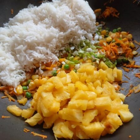 Add cooked rice and diced pineapple to the veggies